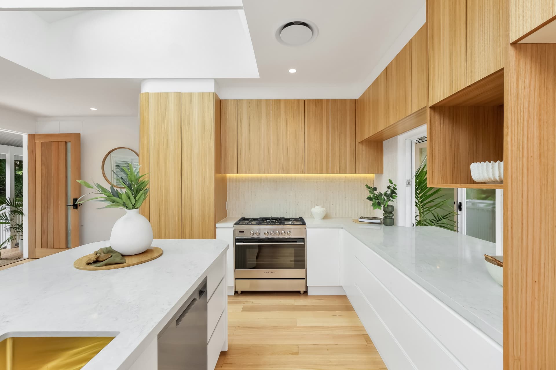 Modern kitchen with oak joinery and stone benchtops — real estate photography by Estate Media Co