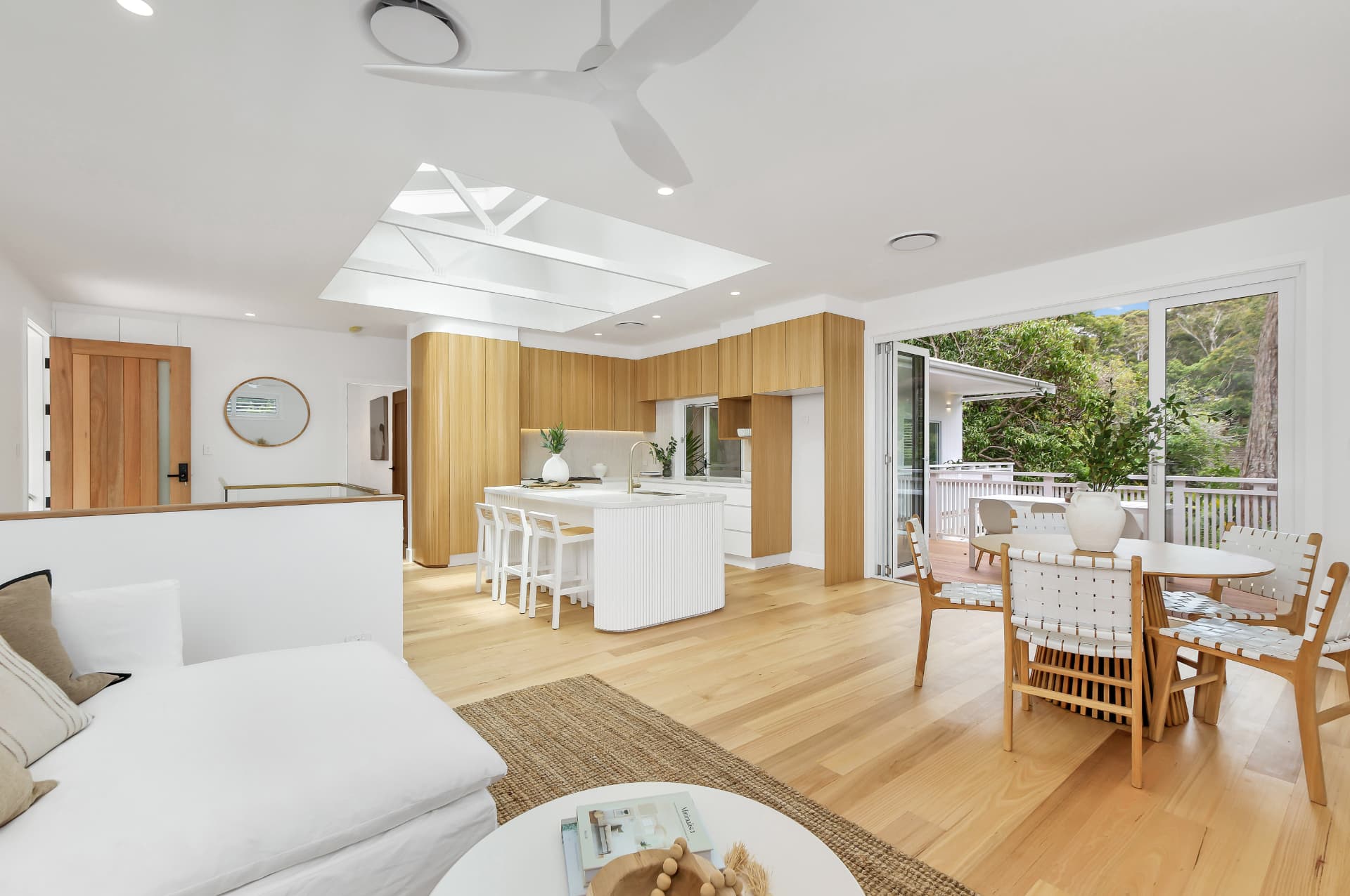 Open plan living, kitchen and dining with timber floors — real estate photography by Estate Media Co